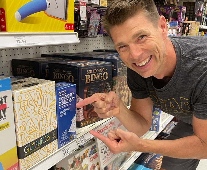 Eric Olsen pointing to Glyphics on the game shelf
